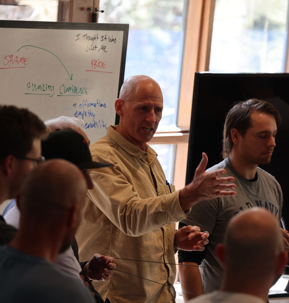 A group session at the lodge, gathered around a whiteboard